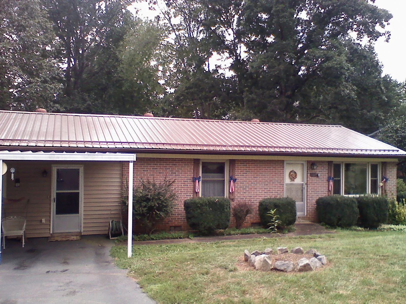 Bronze metal roof and carport on a brick ranch home — Roof Repair work by our crew in Danville